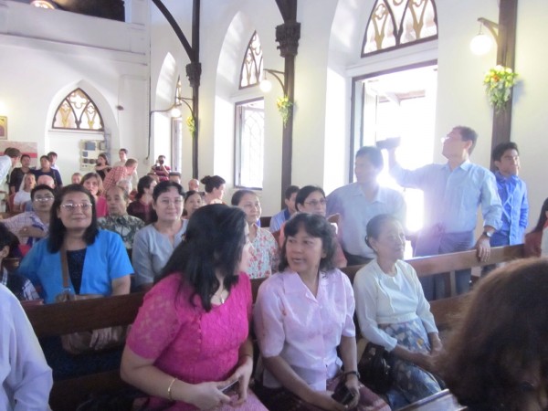 A packed church on Oct. 4, 2014. Tina Minus talks to Winsome Vertannes in the centre. Winsome's mother waits for the service to start.